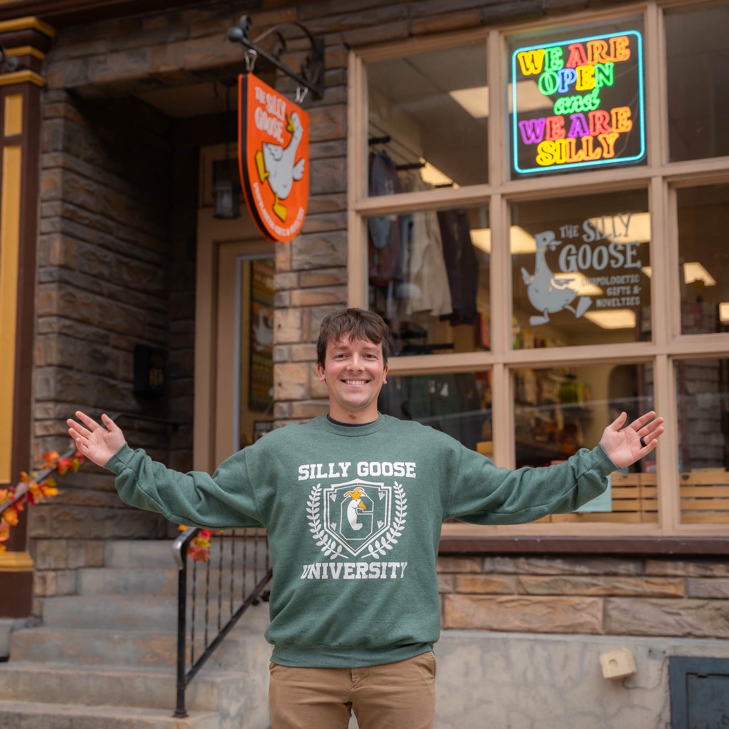 Nate in front of The Silly Goose in Jim Thorpe wearing a green Silly Goose University Crew Neck