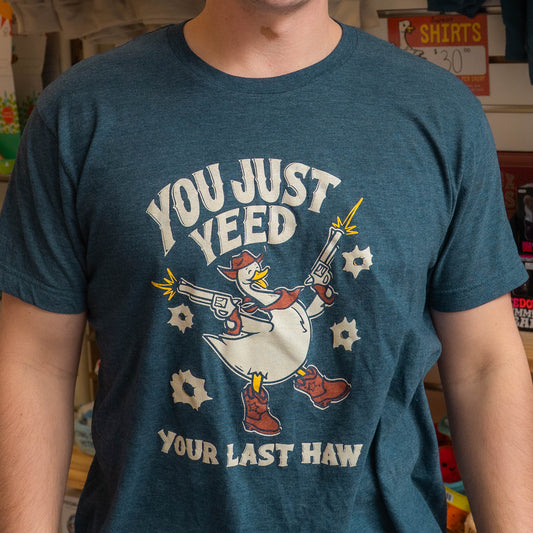 Nate wearing a blue Silly Goose t-shirt with a graphic design of a duck holding a gun and text.