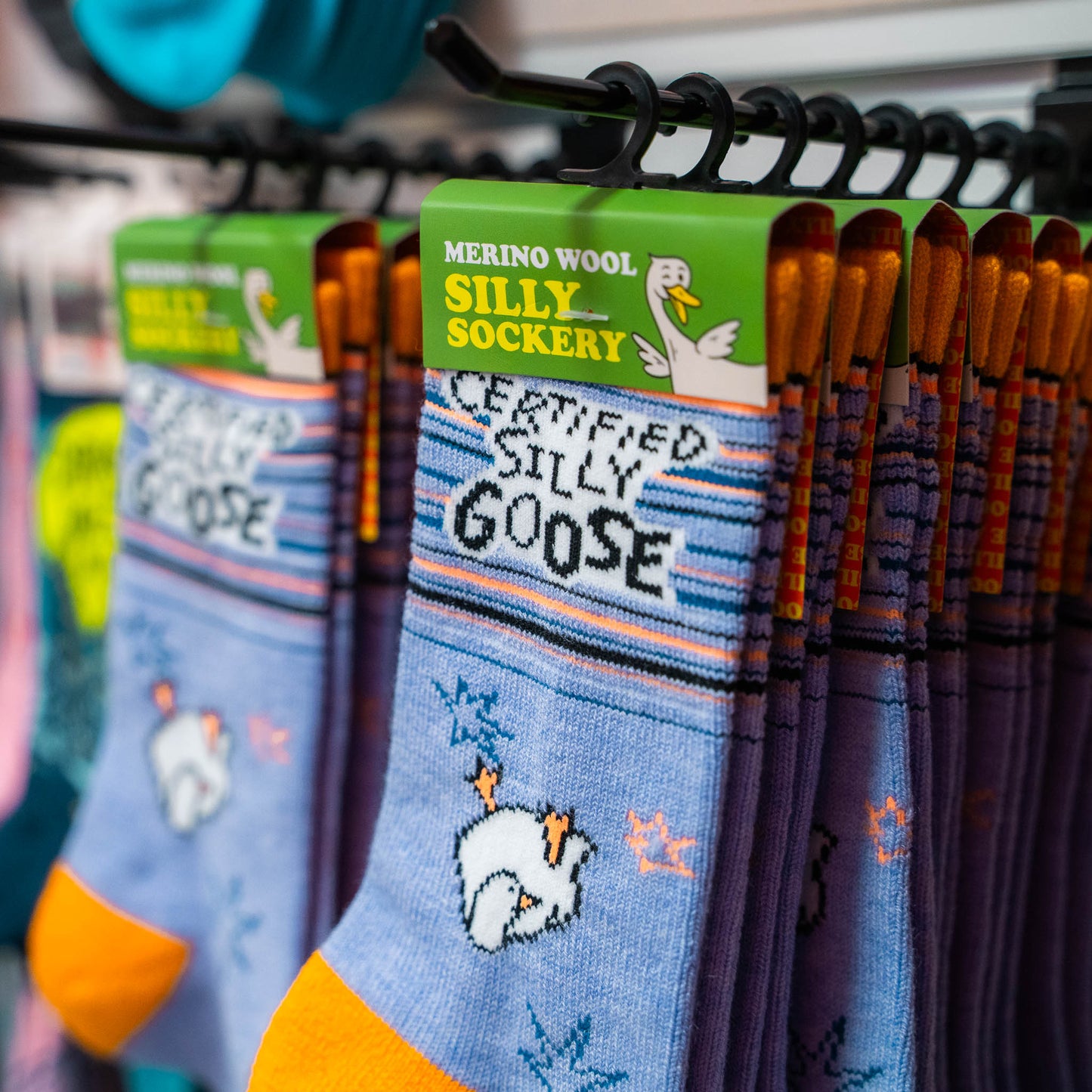 Row of Silly Goose 'Certified Silly Goose' socks with branding on a rack.