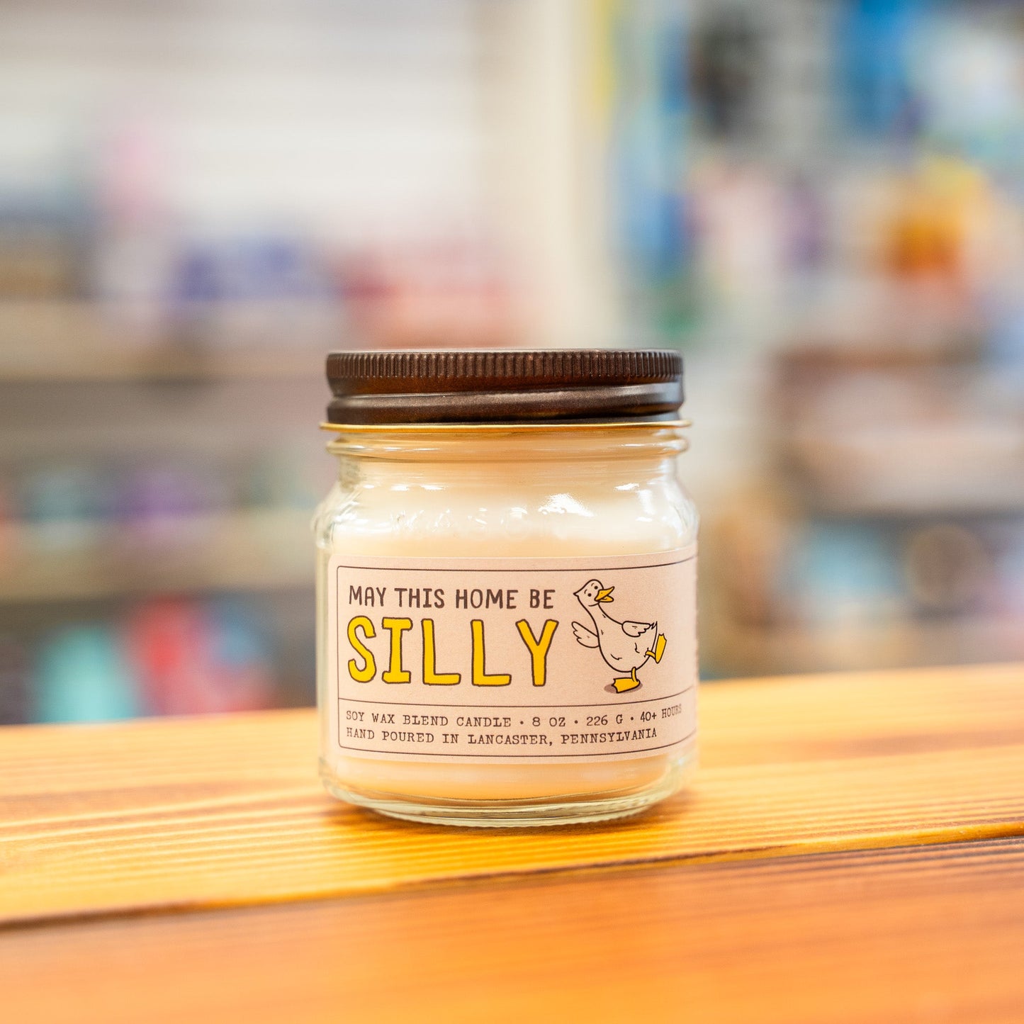 Silly Goose Jar of candle with a humorous label on a wooden surface