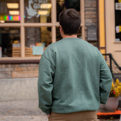 Nate in front of The Silly Goose in Jim Thorpe wearing a green Silly Goose University Crew Neck