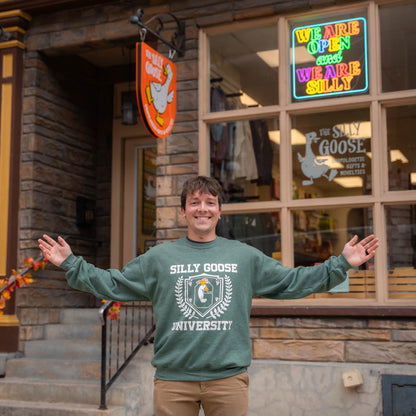 Nate in front of The Silly Goose in Jim Thorpe wearing a green Silly Goose University Crew Neck