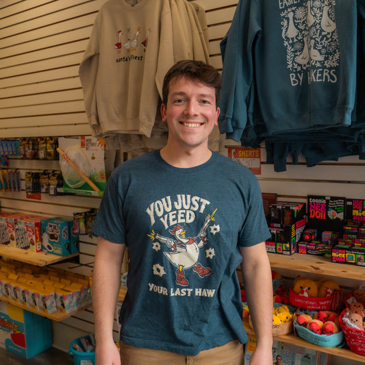 Nate wearing a Silly Goose blue t-shirt with a graphic design in a store setting