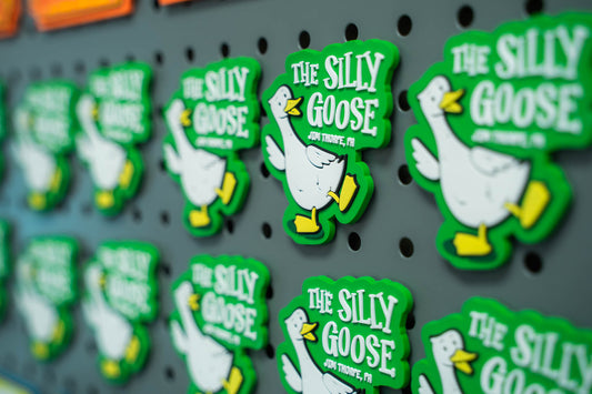 Green and white 'The Silly Goose' magnet on a pegboard